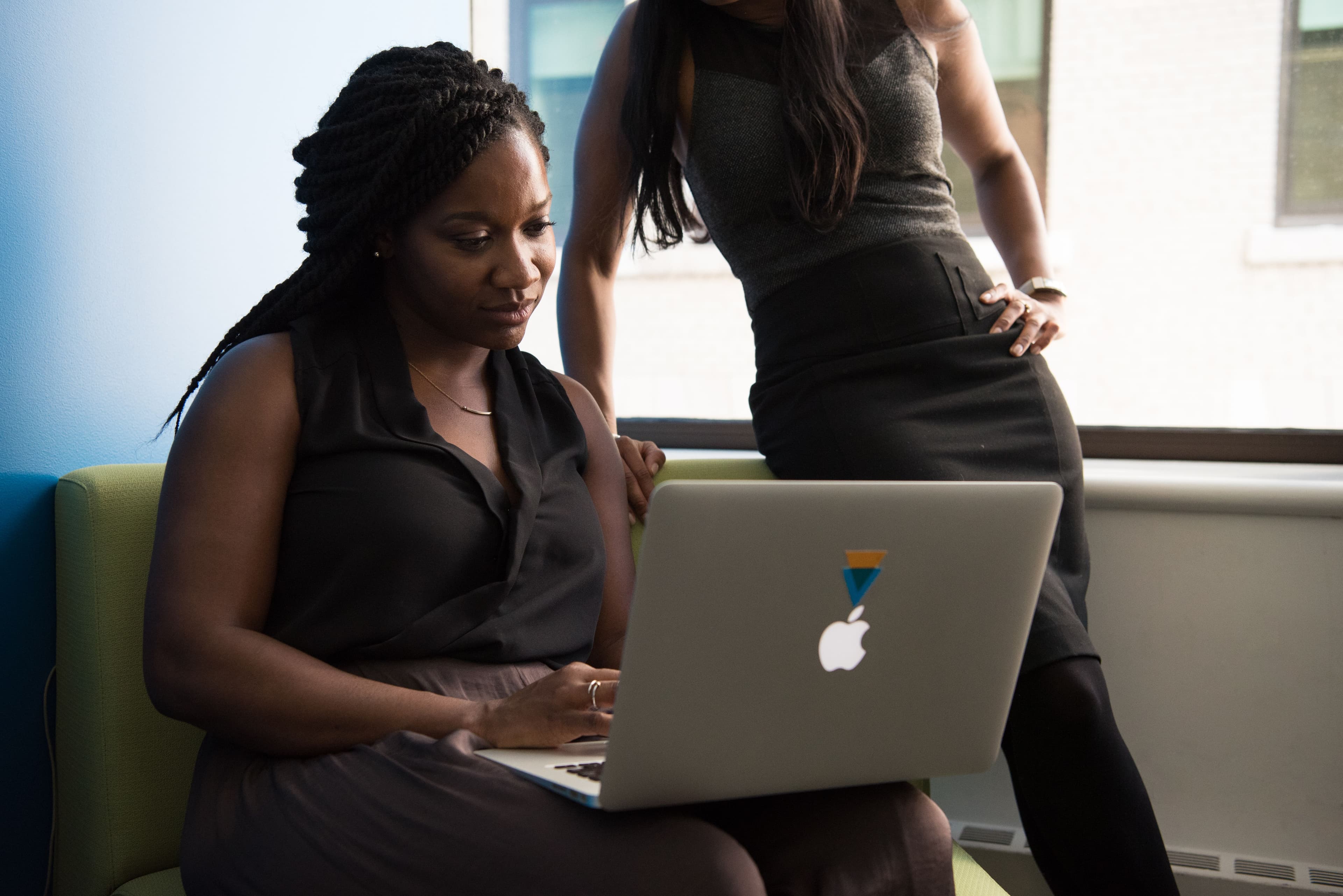 Two colleagues looking at a laptop together in an office