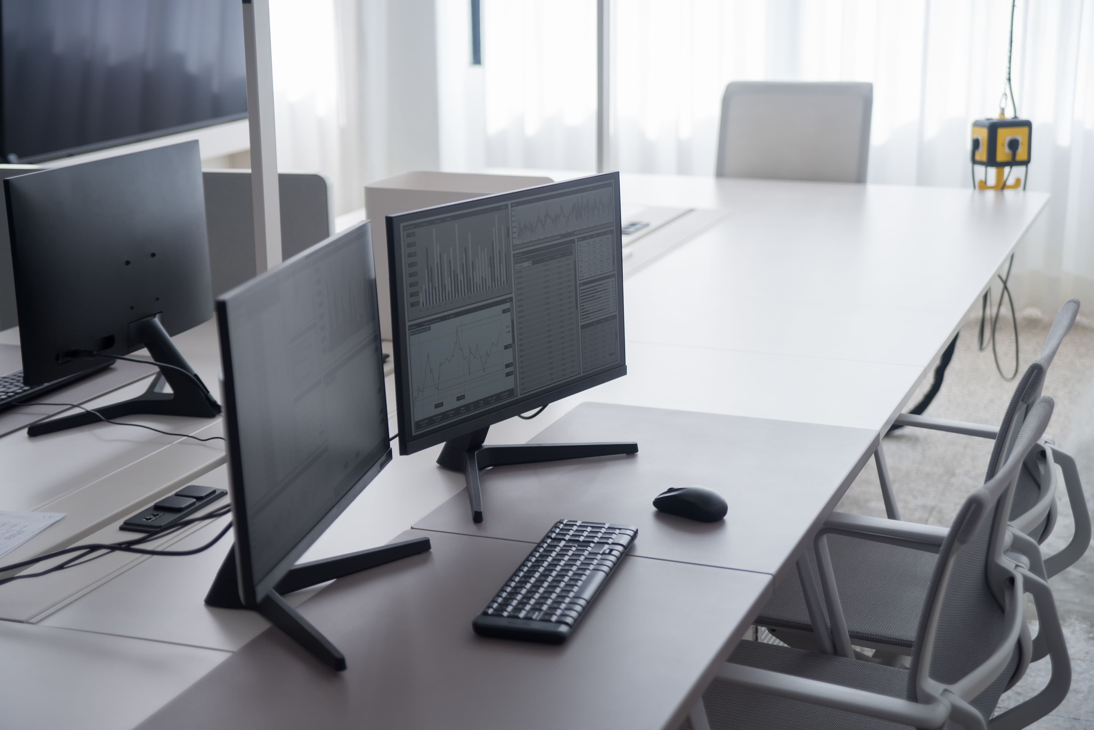 Workstations in an empty office, with charts open on the monitors